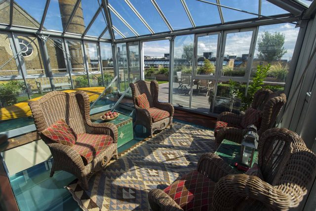Roof terrace with decking, artificial level lawn and LED lighting design at New Concordia Wharf, highlight surfaces and architectural elements in the evenings.