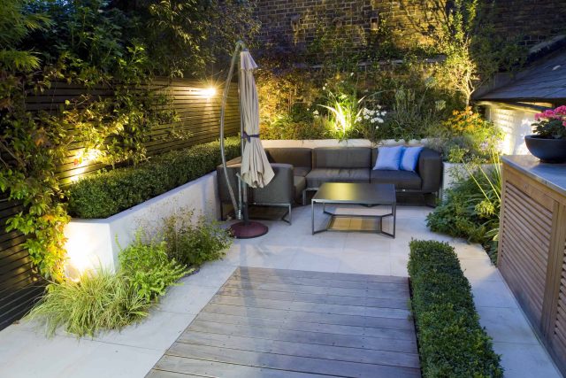 Outdoor room in Sloane Square Chelsea with Gloster exterior furniture and lighting and timber decking, roof terrace designer, sandstone paving raised beds.