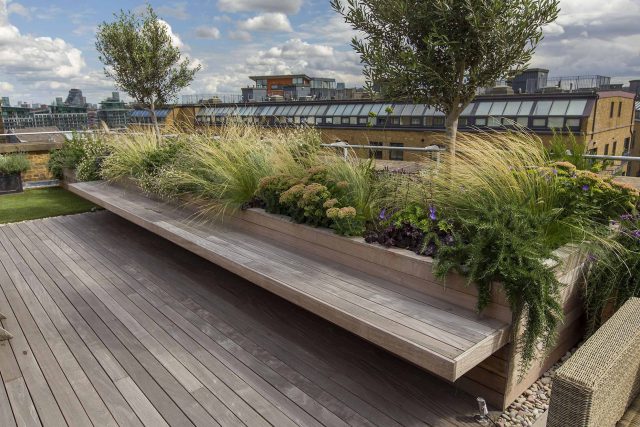 Roof terrace with decking, artificial level lawn and LED lighting design at New Concordia Wharf, highlight surfaces and architectural elements in the evenings.