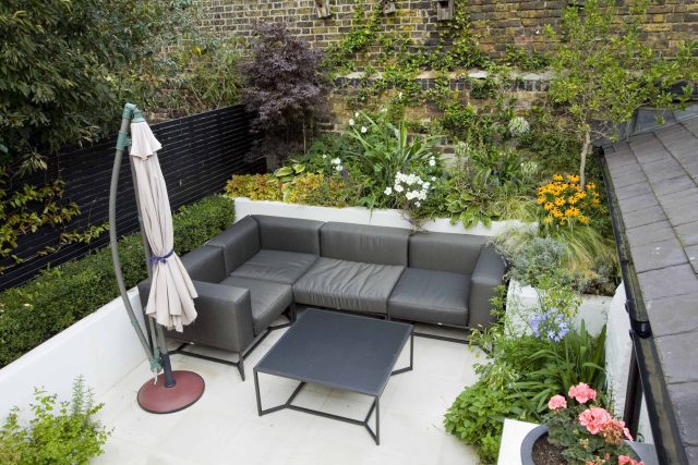 Outdoor room in Sloane Square Chelsea with Gloster exterior furniture and lighting and timber decking, roof terrace designer, sandstone paving raised beds.