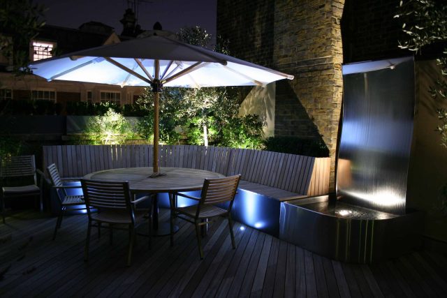 Contemporary Roof Terrace garden designer in Baker Street Marylebone, a stunning water feature curved bench cladded in iroko to create an illusion of space.