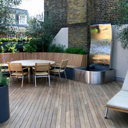 Contemporary Roof Terrace garden designer in Baker Street Marylebone, a stunning water feature curved bench cladded in iroko to create an illusion of space.