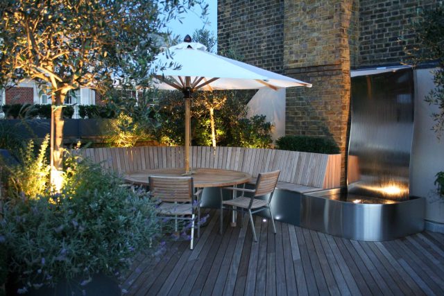 Contemporary Roof Terrace garden designer in Baker Street Marylebone, a stunning water feature curved bench cladded in iroko to create an illusion of space.