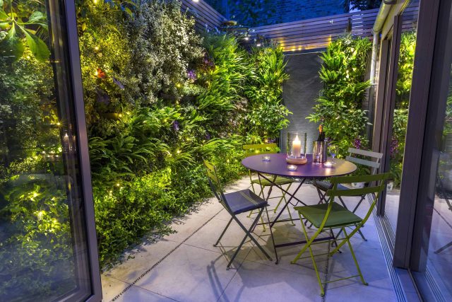 Kensington Courtyard Garden design, living green walls, illuminated with garden lighting in this limited space, a tapestry of green slatted red cedar trellis.