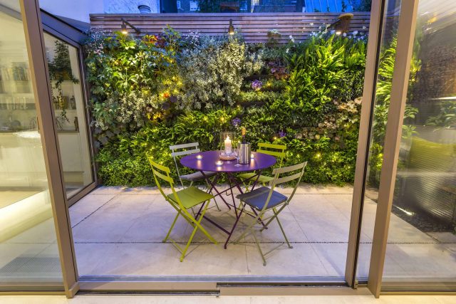 Kensington Courtyard Garden design, living green walls, illuminated with garden lighting in this limited space, a tapestry of green slatted red cedar trellis.