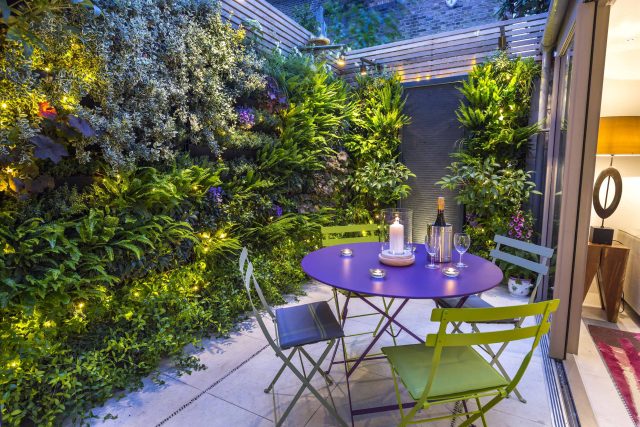 Kensington Courtyard Garden design, living green walls, illuminated with garden lighting in this limited space, a tapestry of green slatted red cedar trellis.