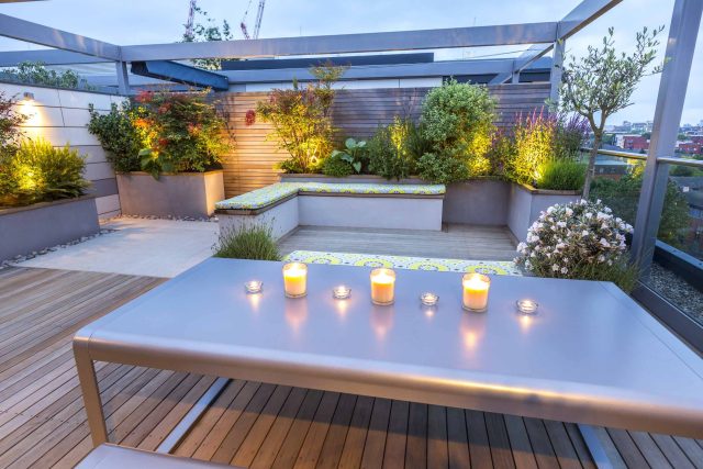 Roof Terrace garden Design for a penthouse apartment King's Cross development, expanse decking storage benches, planters, cedar deck seating area outdoor room.