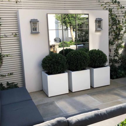 Wandsworth Garden designer initials Artificial Vertical Green Wall toward the rear of the garden breaks up the white of the adjoining trellis and creates space.