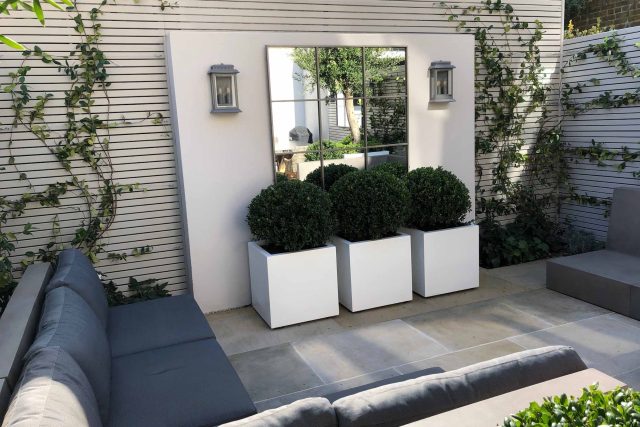 Wandsworth Garden designer initials Artificial Vertical Green Wall toward the rear of the garden breaks up the white of the adjoining trellis and creates space.
