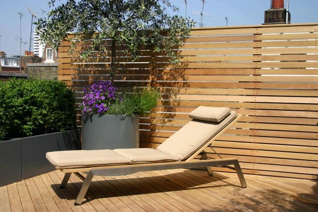 Contemporary Roof Terrace garden designer in Baker Street Marylebone, a stunning water feature curved bench cladded in iroko to create an illusion of space.
