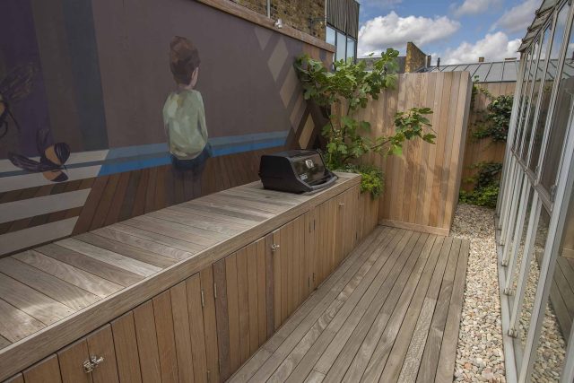 Roof terrace with decking, artificial level lawn and LED lighting design at New Concordia Wharf, highlight surfaces and architectural elements in the evenings.