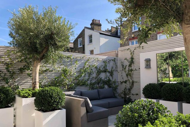 Wandsworth Garden designer initials Artificial Vertical Green Wall toward the rear of the garden breaks up the white of the adjoining trellis and creates space.