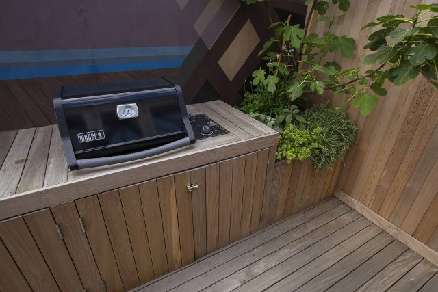 Roof terrace with decking, artificial level lawn and LED lighting design at New Concordia Wharf, highlight surfaces and architectural elements in the evenings.