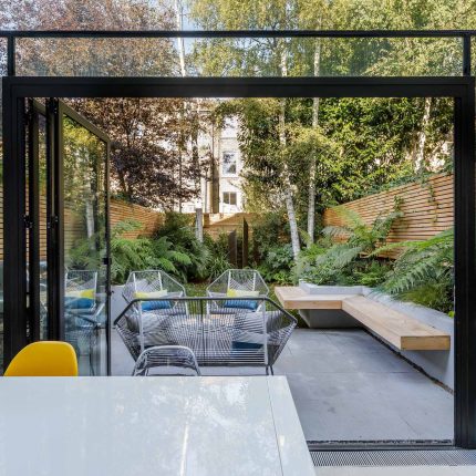 Small, contemporary garden in Islington, designed by Simon Ronan and constructed by The Garden Builders, flanking the terrace are raised beds, floating benches.