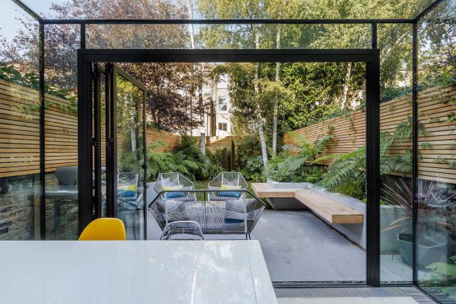 Small, contemporary garden in Islington, designed by Simon Ronan and constructed by The Garden Builders, flanking the terrace are raised beds, floating benches.