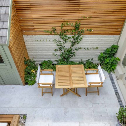 Garden design Vauxhall South London outdoor space, hidden LED strip lighting, polished white pebbles, porcelain paving steps tiles stand slatted cedar trellis.