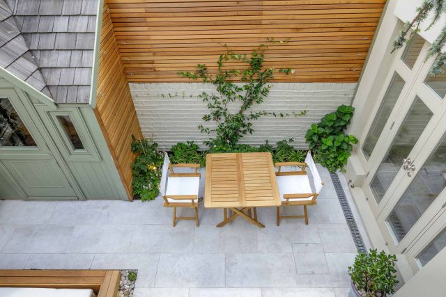 Garden design Vauxhall South London outdoor space, hidden LED strip lighting, polished white pebbles, porcelain paving steps tiles stand slatted cedar trellis.