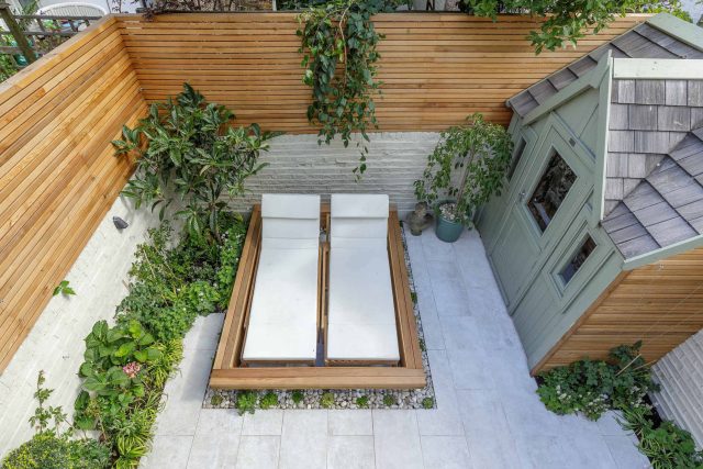 Garden design Vauxhall South London outdoor space, hidden LED strip lighting, polished white pebbles, porcelain paving steps tiles stand slatted cedar trellis.