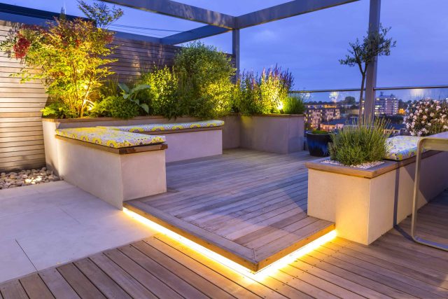Roof Terrace garden Design for a penthouse apartment King's Cross development, expanse decking storage benches, planters, cedar deck seating area outdoor room.
