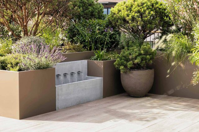 Roof terrace garden designer Belgravia building company contractors Knightsbridge planters, mature plants Hunza lighting, irrigation system Iroko benches design.