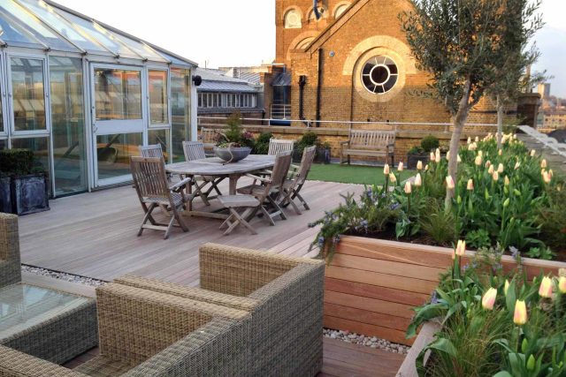 Roof terrace with decking, artificial level lawn and LED lighting design at New Concordia Wharf, highlight surfaces and architectural elements in the evenings.