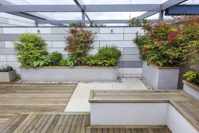 Roof Terrace garden Design for a penthouse apartment King's Cross development, expanse decking storage benches, planters, cedar deck seating area outdoor room.