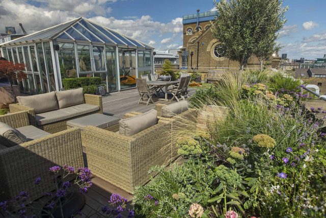 Roof terrace with decking, artificial level lawn and LED lighting design at New Concordia Wharf, highlight surfaces and architectural elements in the evenings.