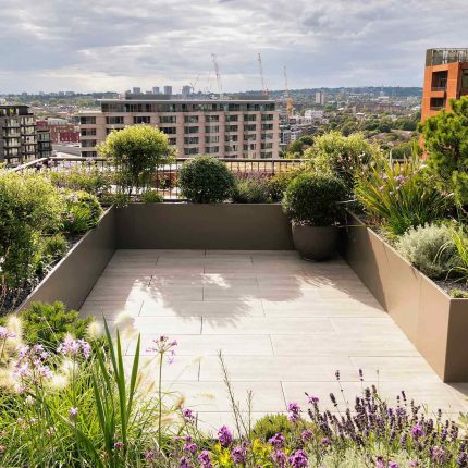 Roof terrace garden designer Belgravia building company contractors Knightsbridge planters, mature plants Hunza lighting, irrigation system Iroko benches design.