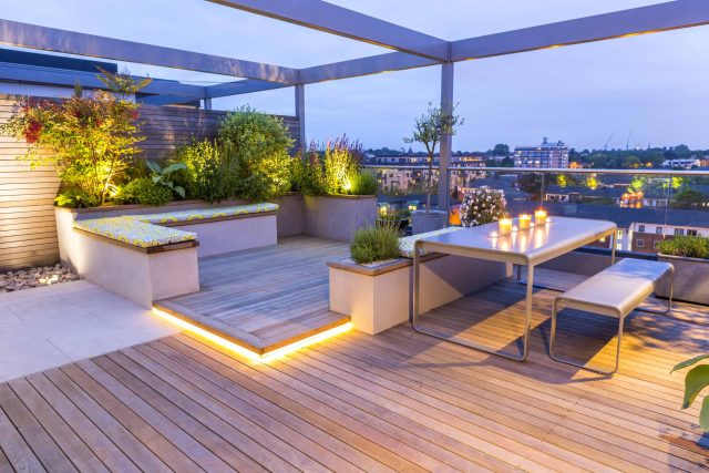 Roof Terrace garden Design for a penthouse apartment King's Cross development, expanse decking storage benches, planters, cedar deck seating area outdoor room.