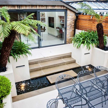 Beautiful London Garden, Clancarty Road, London, new block rendered boundary walls, planting, lighting, submersible water lights, bright contemporary effect.