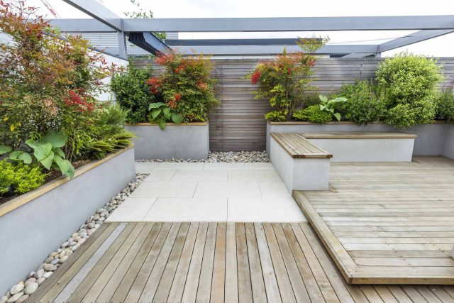 Roof Terrace garden Design for a penthouse apartment King's Cross development, expanse decking storage benches, planters, cedar deck seating area outdoor room.