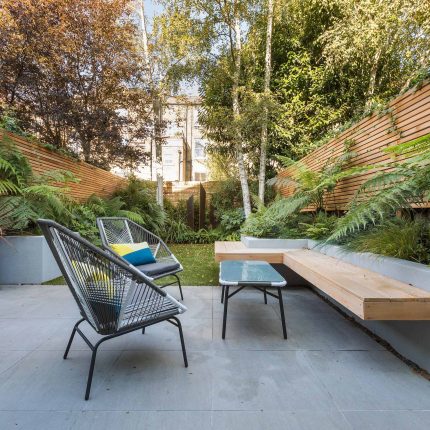 Small, contemporary garden in Islington, designed by Simon Ronan and constructed by The Garden Builders, flanking the terrace are raised beds, floating benches.