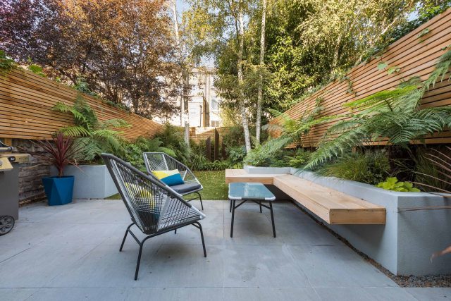 Small, contemporary garden in Islington, designed by Simon Ronan and constructed by The Garden Builders, flanking the terrace are raised beds, floating benches.