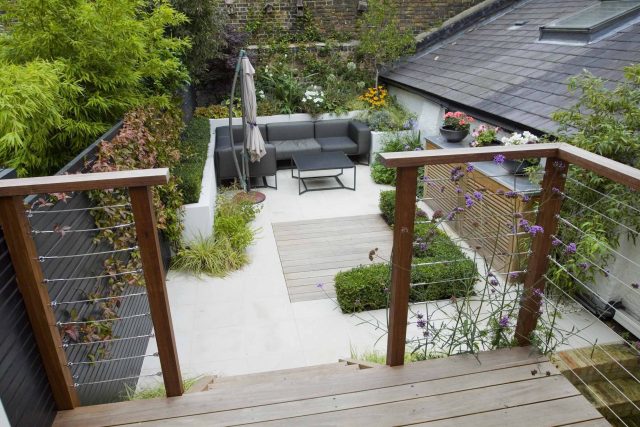 Outdoor room in Sloane Square Chelsea with Gloster exterior furniture and lighting and timber decking, roof terrace designer, sandstone paving raised beds.
