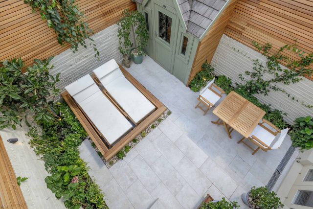 Garden design Vauxhall South London outdoor space, hidden LED strip lighting, polished white pebbles, porcelain paving steps tiles stand slatted cedar trellis.
