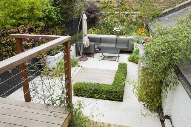 Outdoor room in Sloane Square Chelsea with Gloster exterior furniture and lighting and timber decking, roof terrace designer, sandstone paving raised beds.