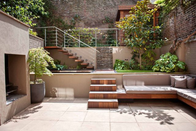 City design jacuzzi garden low maintenance with artificial lawn, stacked stone water wall BBQ Fire place feature, Hampstead Village, natural stone led lighting.