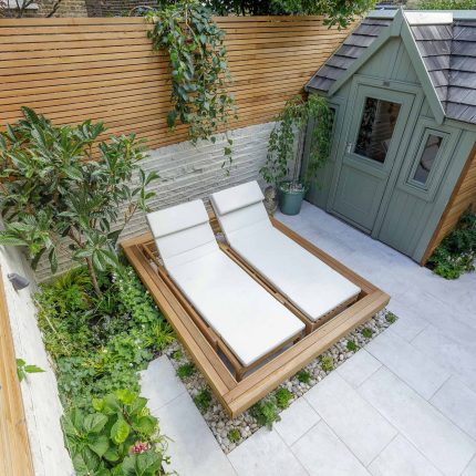 Garden design Vauxhall South London outdoor space, hidden LED strip lighting, polished white pebbles, porcelain paving steps tiles stand slatted cedar trellis.