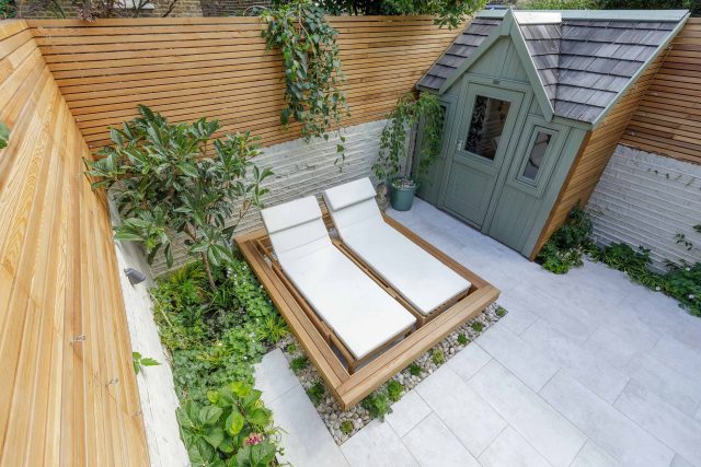 Garden design Vauxhall South London outdoor space, hidden LED strip lighting, polished white pebbles, porcelain paving steps tiles stand slatted cedar trellis.