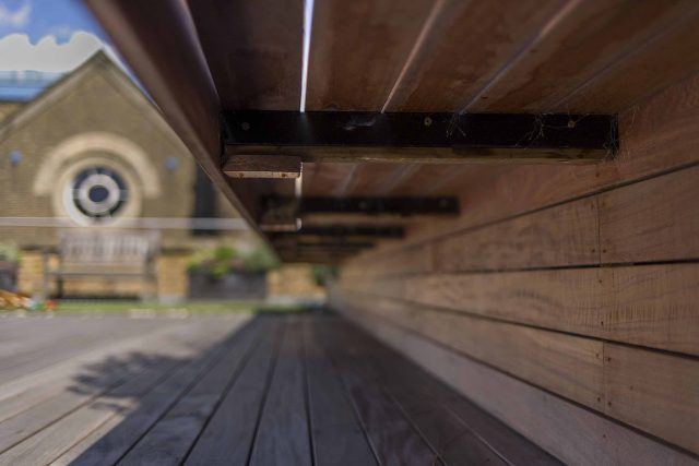 Roof terrace with decking, artificial level lawn and LED lighting design at New Concordia Wharf, highlight surfaces and architectural elements in the evenings.