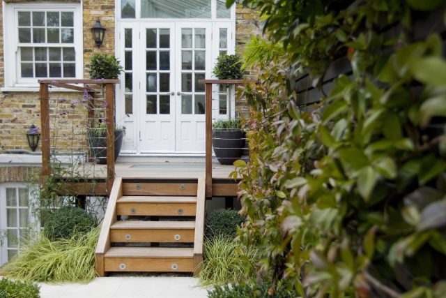 Outdoor room in Sloane Square Chelsea with Gloster exterior furniture and lighting and timber decking, roof terrace designer, sandstone paving raised beds.