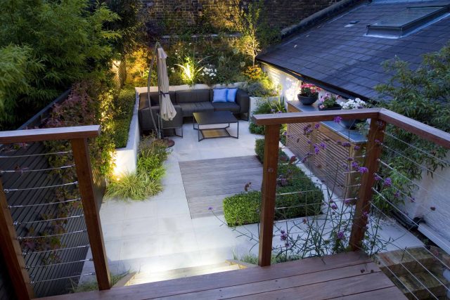 Outdoor room in Sloane Square Chelsea with Gloster exterior furniture and lighting and timber decking, roof terrace designer, sandstone paving raised beds.