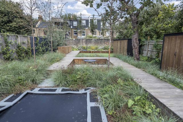 Garden designer contemporary family garden Chiswick friendly space decking, dining table, an aluminum pergola in powder-coated finish, a cozy and warm outlook.