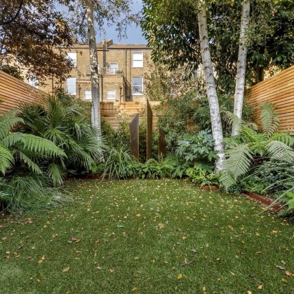 Small, contemporary garden in Islington, designed by Simon Ronan and constructed by The Garden Builders, flanking the terrace are raised beds, floating benches.