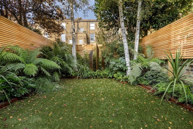 Small, contemporary garden in Islington, designed by Simon Ronan and constructed by The Garden Builders, flanking the terrace are raised beds, floating benches.