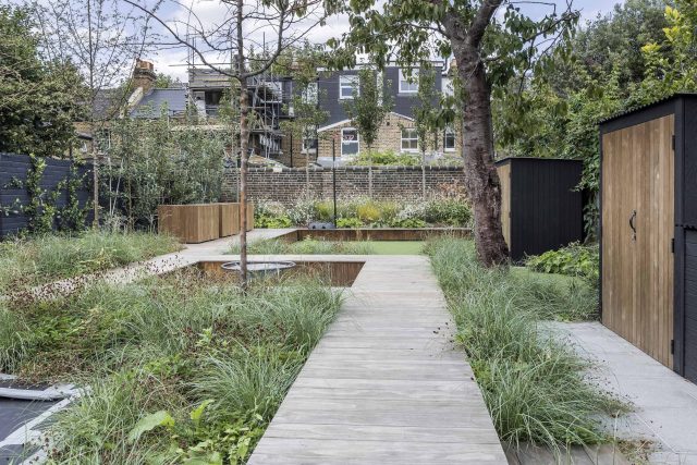 Garden designer contemporary family garden Chiswick friendly space decking, dining table, an aluminum pergola in powder-coated finish, a cozy and warm outlook.