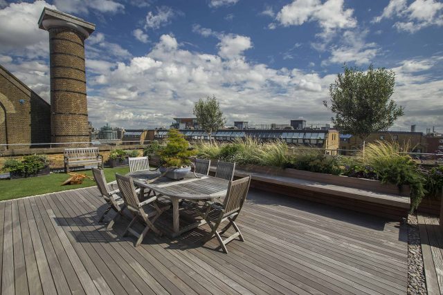 Roof terrace with decking, artificial level lawn and LED lighting design at New Concordia Wharf, highlight surfaces and architectural elements in the evenings.