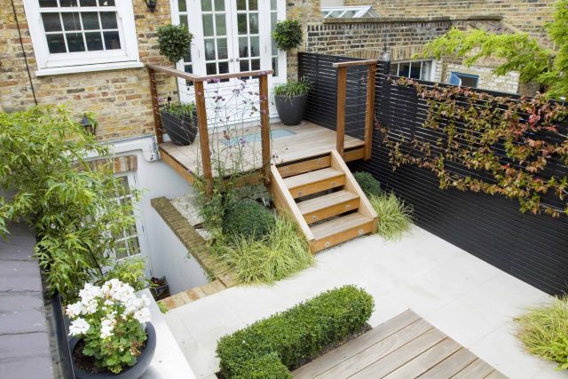 Outdoor room in Sloane Square Chelsea with Gloster exterior furniture and lighting and timber decking, roof terrace designer, sandstone paving raised beds.