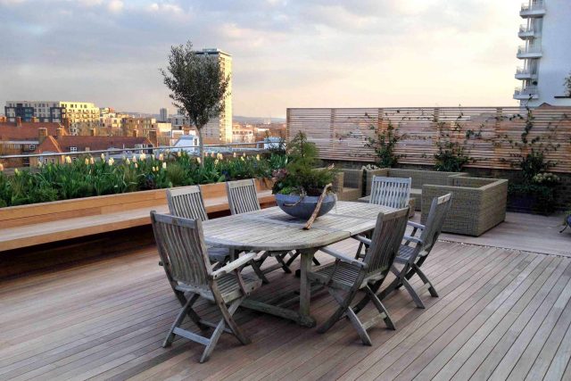 Roof terrace with decking, artificial level lawn and LED lighting design at New Concordia Wharf, highlight surfaces and architectural elements in the evenings.