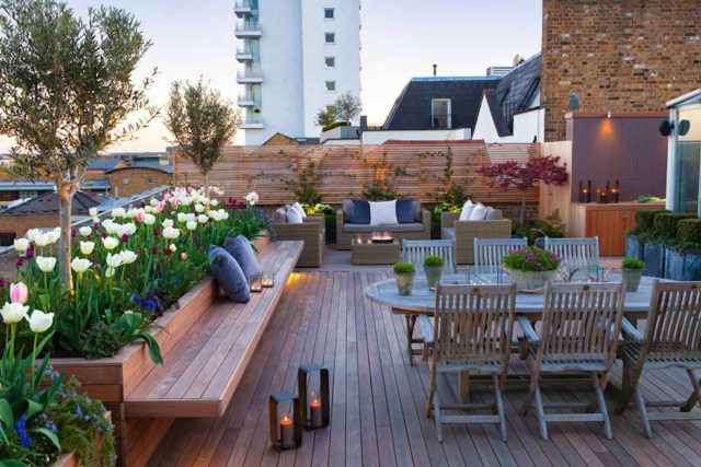 Roof terrace with decking, artificial level lawn and LED lighting design at New Concordia Wharf, highlight surfaces and architectural elements in the evenings.